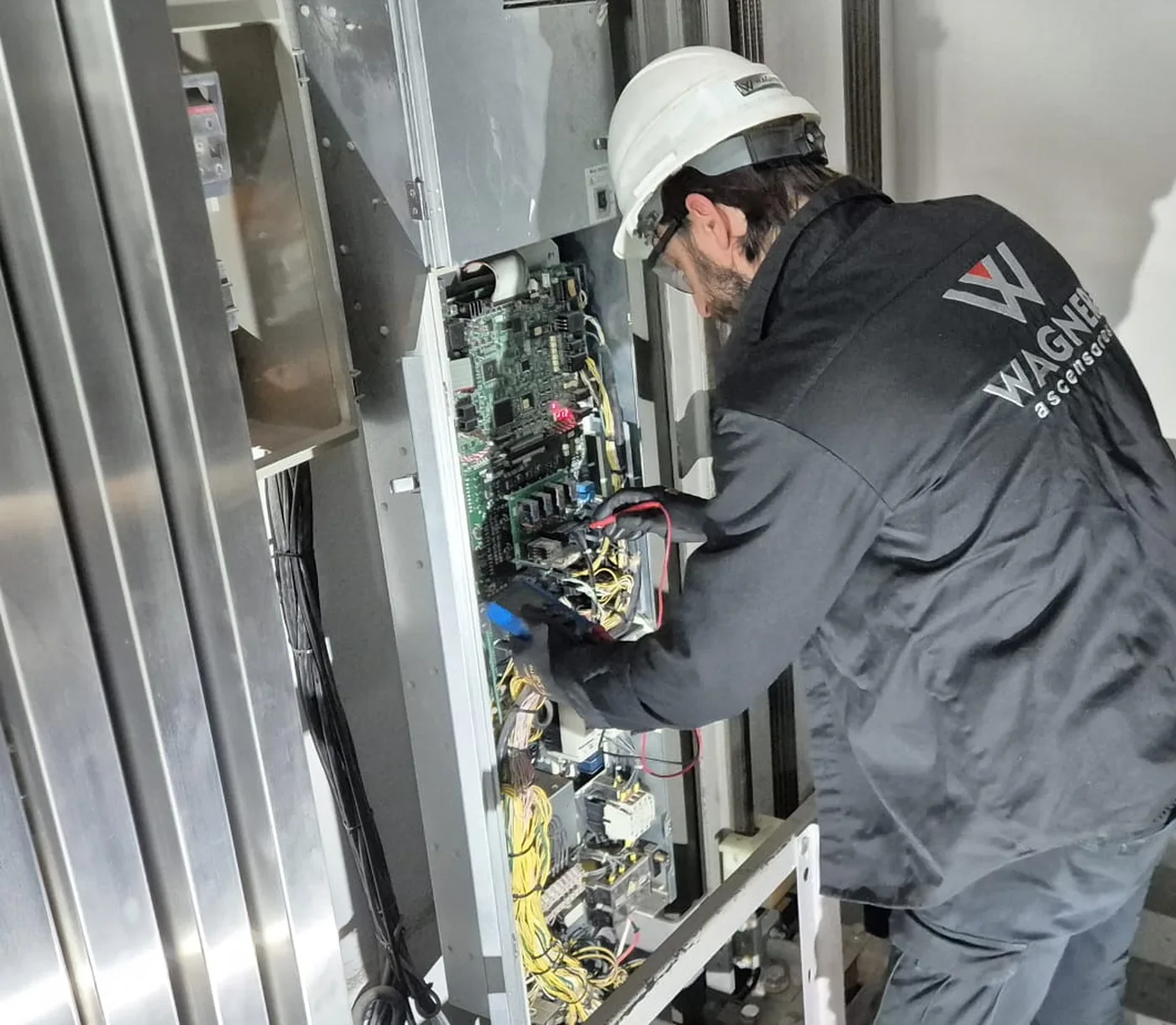 Técnico de ascensores trabajando junto a un equipo